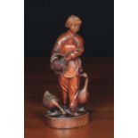 A Chinese Carved Hardwood Figure of a Girl feeding two geese with small inset glass eyes,