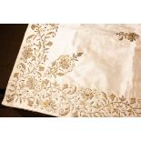 An Ivory Silk Satin Runner embroidered in gold metallic threads with a border of undulating flowers