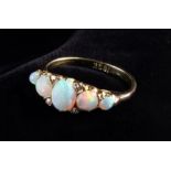 A Lady's 18 Carat Yellow Gold Ring set with five opals and four small diamonds flanking the central