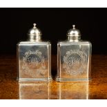 A Pair of George I Silver Tea-caddies of canted rectangular form with domed lids.