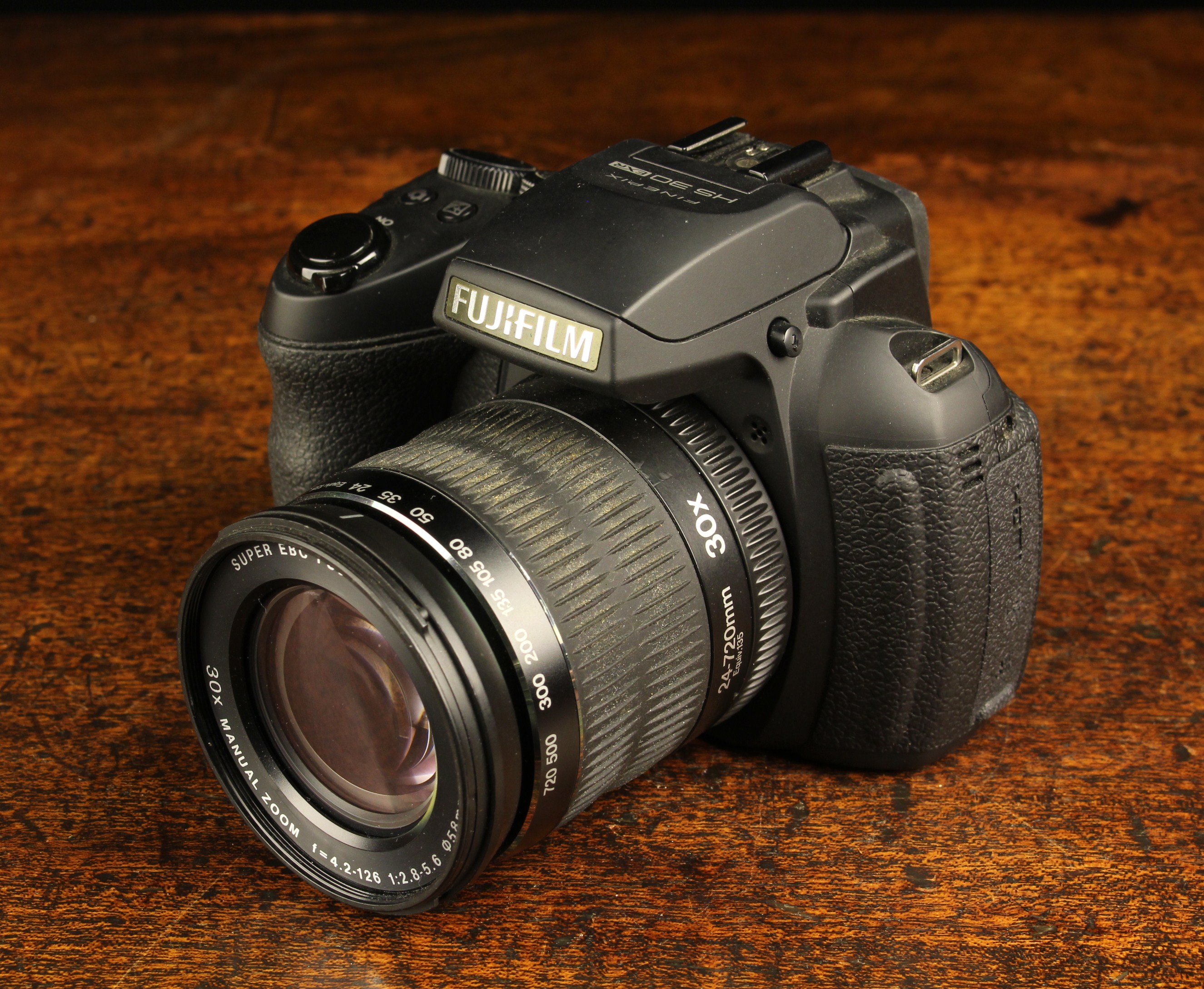 A Fujifilm HS 30 Digital Camera with 24-72 mm zoom lens, a Kenko 4 GB card,
