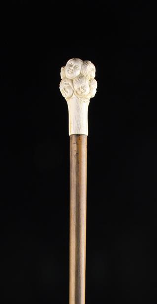 An Antique Walking Stick with a carved bone handle in the form of a cluster of twelve children's