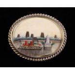 An Oval White Metal Brooch inset with a miniature scenic painting on bone and edged in a ropetist