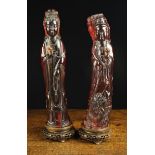 Two Carved Cherry Amber Guanyins mounted on carved hardwood stands, 12½" (32 cm) in height.