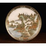 A Japanese Satsuma Dish intricately decorated with a mountain landscape depicting figures, pagodas,