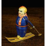 A Vintage Tin Plate Wind-up Toy of Skiing Lady wearing a red beret and blue ski-suit with patterned
