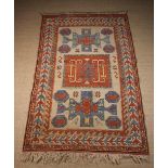 A Wool Carpet woven in mid blue and light red on an ivory ground with bold geometric motifs