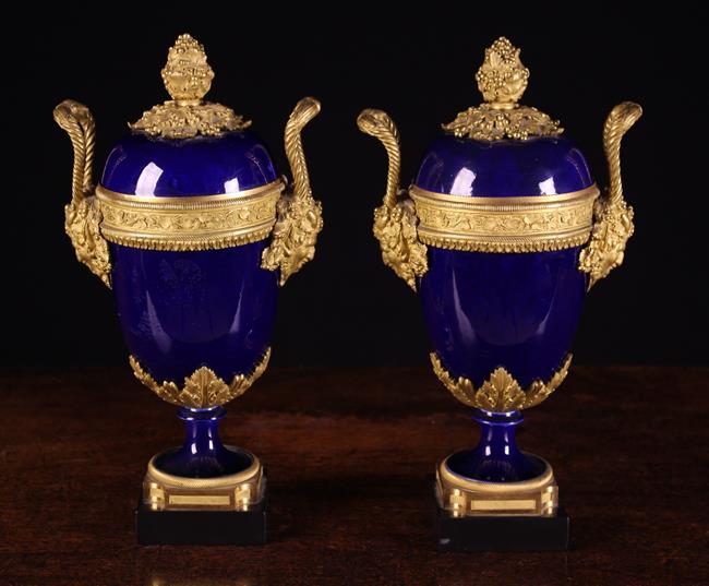 A Pair of Sèvres Style Porcelain Garniture Urns with decorative gilt bronze mounts.