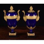 A Pair of Sèvres Style Porcelain Garniture Urns with decorative gilt bronze mounts.