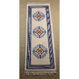 A Machine Made Ivory Ground Wool Runner with three floret designs in a central panel within a