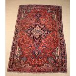 A Persian Wool Carpet woven in dark blue, mid blue,