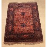 A Hand-tied Turkeman Carpet woven predominantly in a palette of browns and inky blue/black on a