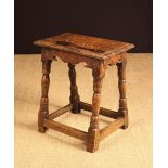 A Late 17th Century Oak Joint Stool having a moulded top above serpentine cut rails and turned