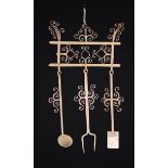 A Decorative Wrought Iron Wall rack with three hooks bearing toasting fork,