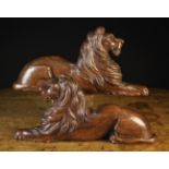 A Pair of 18th Century Relief Carved Oak Recumbent Lions, 9½" (24 cm) high, 20" (51 cm) in width.