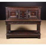 A Small Charles I Oak Livery Cupboard. The edge-moulded plank top above a twin-doored cupboard.