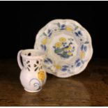 A Delft Puzzle Jug painted with a flowering plant in yellow,