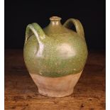 A 19th Century French Provincial Twin-handled Flask of ovoid form with green semi-glaze,