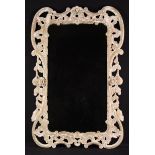 An 18th Century Irish Wall Mirror in a decorative pierced frame of stripped gessoed pine carved