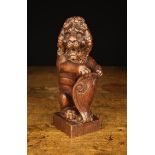 An 18th Century Carved Oak Newel Post Finial in the form of a Heraldic Lion Sejant.