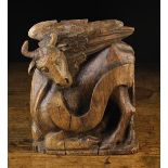 A Gothic Oak Carving of Winged Bull; symbol of the Evangelist Luke entwined with banderole,