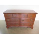 A 20th Century reproduction seven drawer chest, 133cm wide x 82cm H