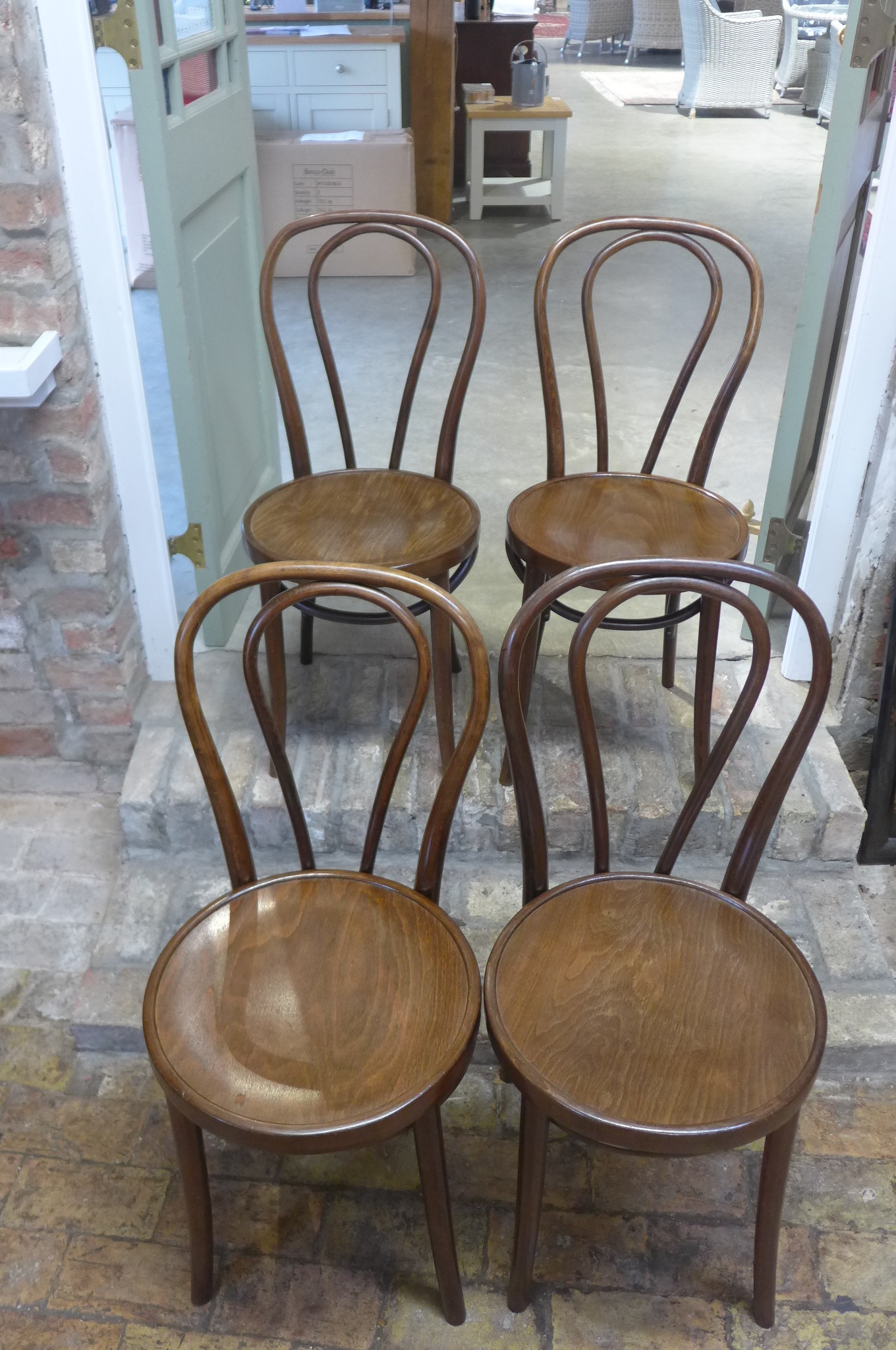 A set of four bentwood dining chairs, bares a label for The Classic Furniture Company Ltd, Newport