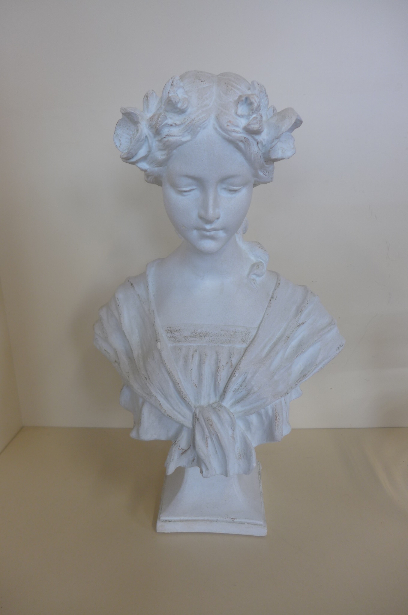 A stone effect bust of a young lady, 47cm tall