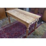 A Victorian style stripped pine table with a long drawer on turned legs, 81cm tall x 153cm x