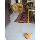 An Ercol standard reading lamp with wicker shade, 140cm tall