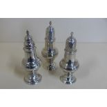 A pair of Georgian silver peppers, London 1816/17 - 15cm tall, maker TI, and a single pepper,