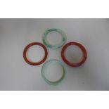 Two jade type bangles and two cornelian bangles