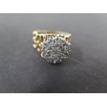 An 18ct gold and diamond cluster ring on pierced shank set with nineteen small round cut diamonds,