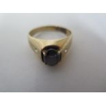 A gents 14ct gold signet ring set with a cabachon polished stone, with two small white stones,
