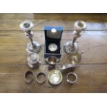 Assorted silverware including a mustard, a pair of weighted candlesticks and a £5 coin, weighable