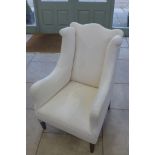 An Edwardian upholstered wing back armchair, 94cm H x 64cm W x 75cm D