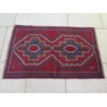 A hand knotted woollen Baluchi rug - 134x85cm