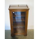 A Victorian crossbanded mahogany cupboard with a brass gallery and glazed door - 99cm tall x 54cm