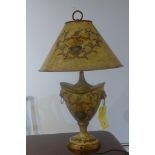 A decorative urn shaped table lamp with shade