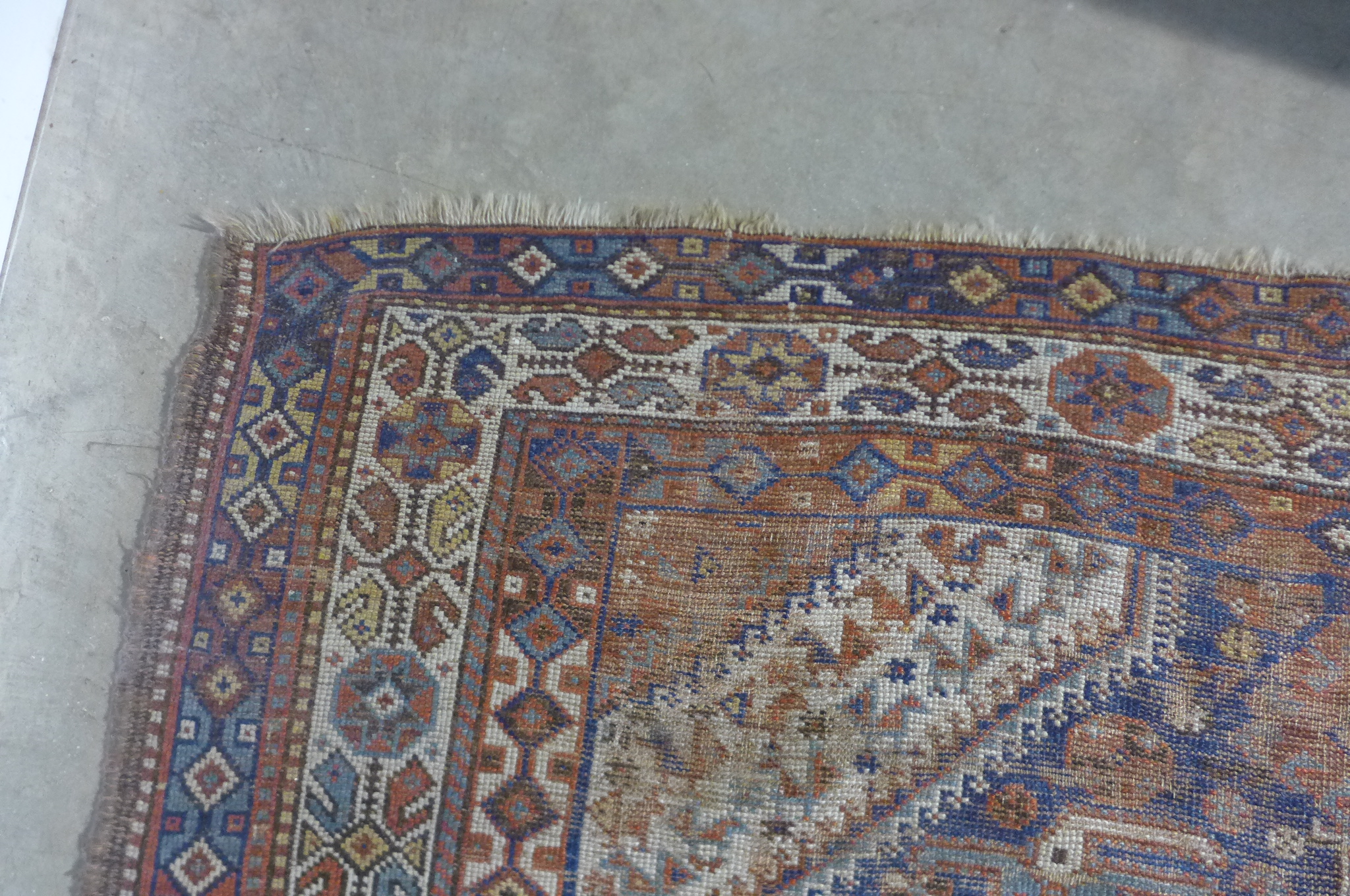 A vintage hand knotted Eastern woollen rug, 302cm x 206cm, in worn condition and some fading - Image 7 of 8