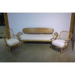 A Lucian Ercolani Ercol light elm and beech panel back spindle arm settee/day bed with two