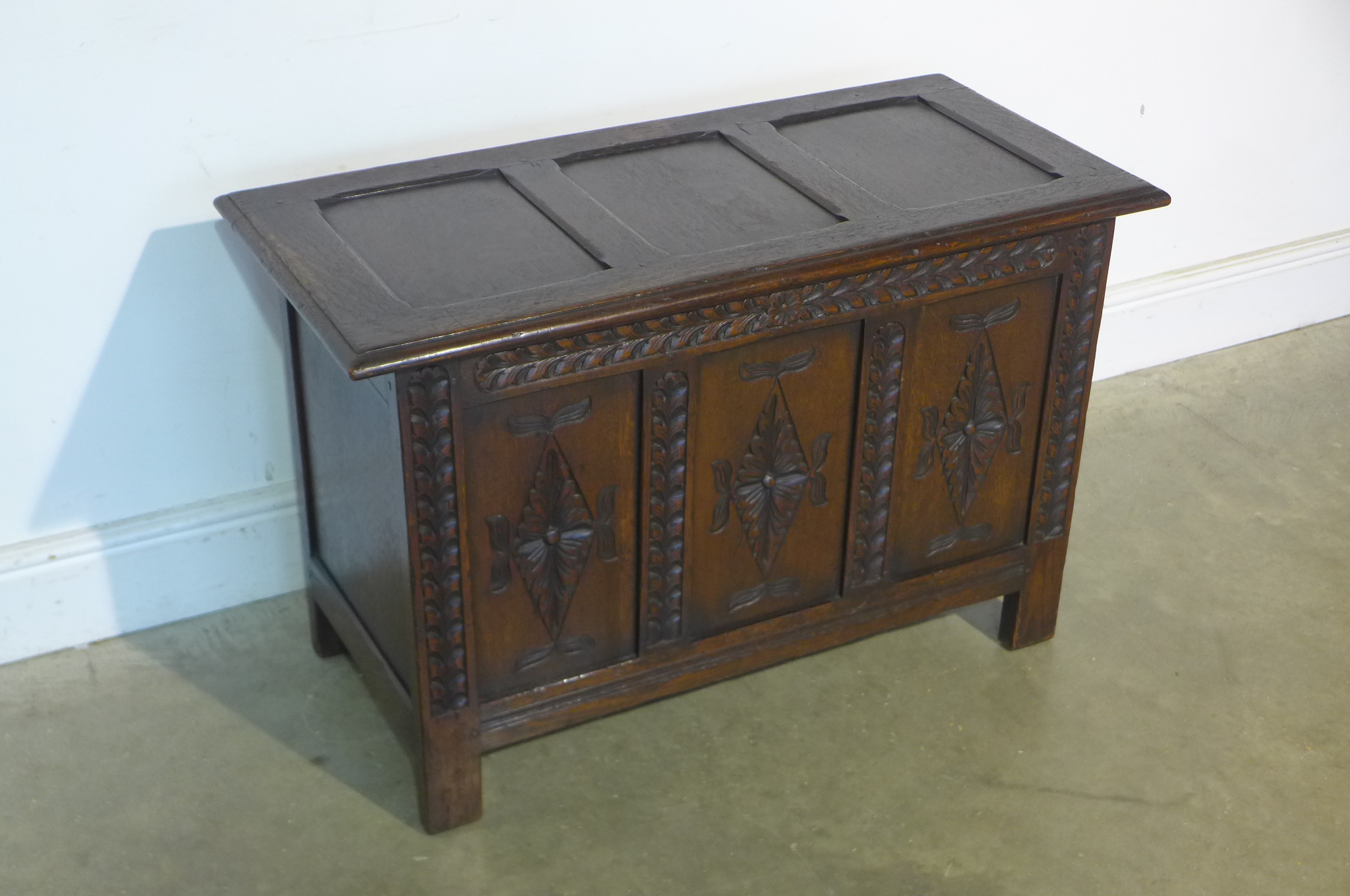 A 17th century style carved oak panelled coffer, 59cm tall x 91cm x 44cm - in good polished