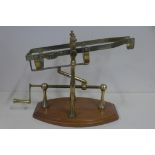 A brassed hand crank wine pourer on wooden stand, 23cm tall x 32cm long