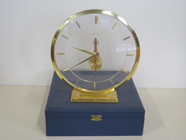 A Jaeger-leCoultre mystery clock with gilt case and baton markers, 19cm tall with original box,