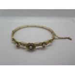 A gold and seed hinged bracelet, the pearls set in floral form mounts, weight approx 10.04 grams,