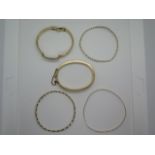 A collection of five 9ct gold bangles and bracelets including a hinged three section bracelet,