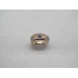 A 9ct pale rose gold diamond and sapphire gypsy ring set with a central sapphire flanked by two