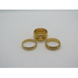 Three 22ct yellow gold wedding bands, two plain, one with decoration, sizes L and M, total weight