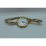 A 9ct gold manual wind wristwatch on a 9ct sprung strap with enamel dial running, total weight