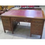 A late Victorian/Edwardian mahogany eight drawer one piece desk, with a leather inset top standing